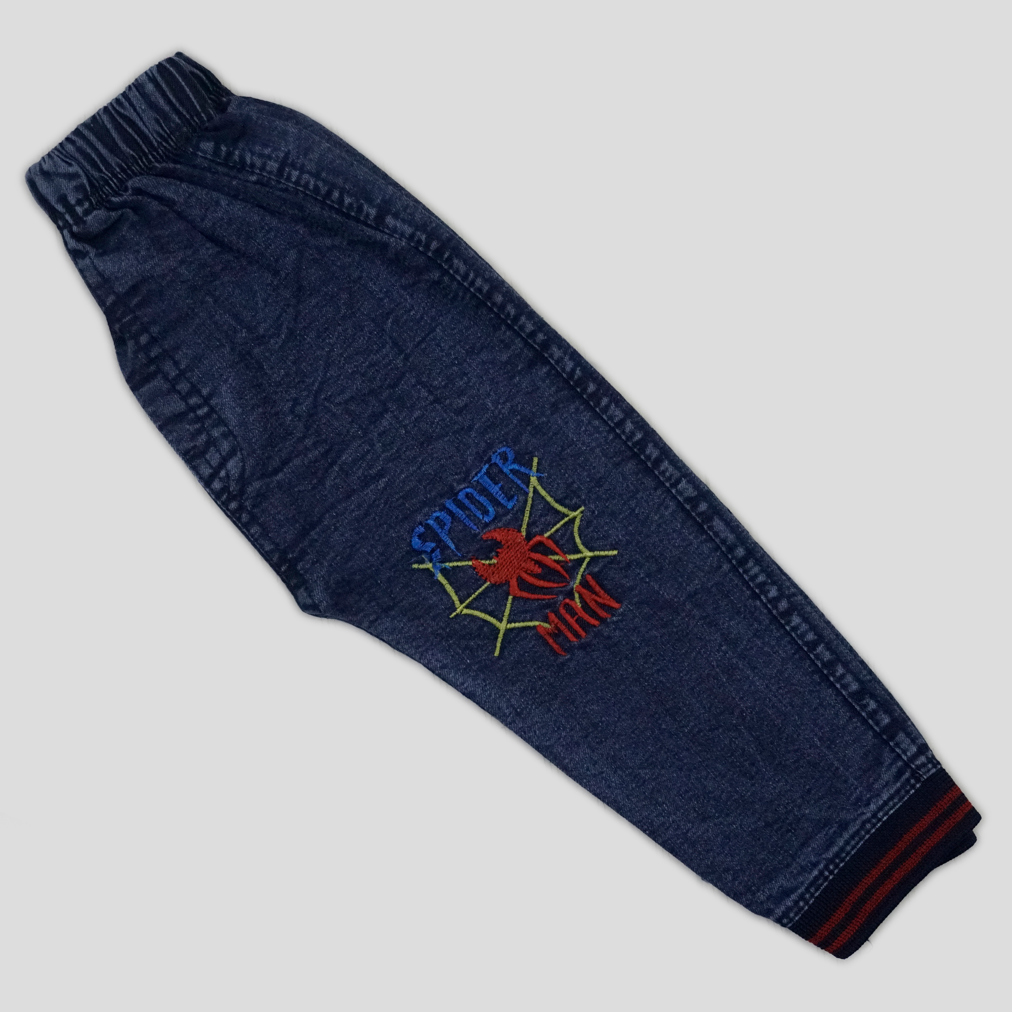 Child wearing a red Spider-Man shirt and blue pants in a home setting