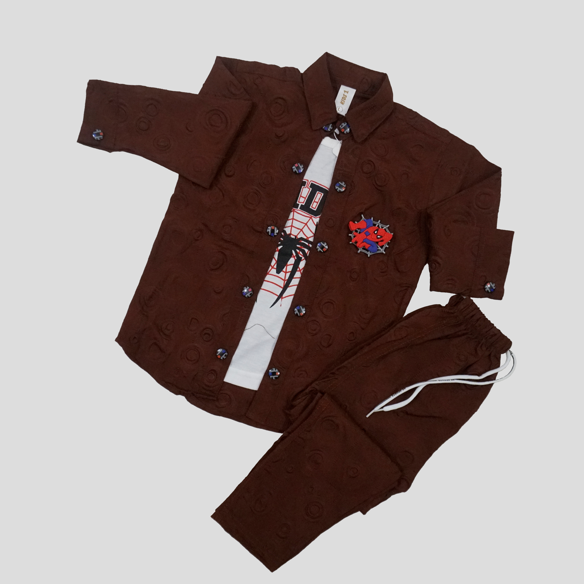 Child wearing a brown outfit with a graphic t-shirt in a room with toys and colorful boxes.